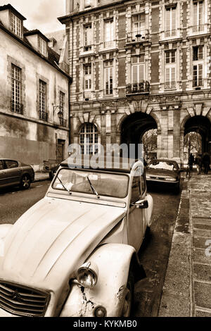 Paris France, un français classique voiture garée dans une rue près de la Place des Vosges. Le modèle Citroën Deux Chevaux est un établissement emblématique de l'automobile de Paris. Sepia Banque D'Images