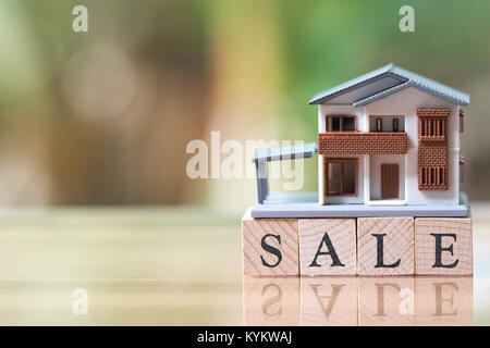 Un modèle de maison modèle est placé sur bois mot vente . comme arrière-plan property real estate concept avec copie espace pour votre texte ou dessin. Banque D'Images