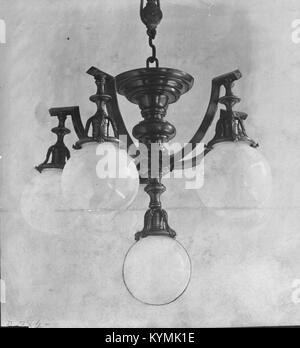Une image historique d'un lustre installé au Harvard Club à New York. Conçu par E. F. Caldwell & Co, cet élégant luminaire en verre et métal est un exemple emblématique de l'éclairage du début du XXe siècle, reflétant le style architectural de McKim, Mead & White. Banque D'Images