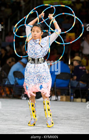 Une photographie colorée et historique illustrant une danse cérémonielle autochtone, prise à un Powwow en 2007. L'image montre une fille amérindienne exécutant une danse traditionnelle, avec des éléments de danse du cerceau, capturant l'importance culturelle de l'événement. Banque D'Images