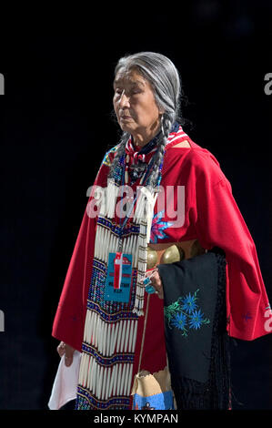 Une photographie de l'événement Powwow de 2005, capturant une femme amérindienne âgée portant un châle rouge et une tenue traditionnelle. L'image reflète le patrimoine culturel des communautés amérindiennes. Banque D'Images