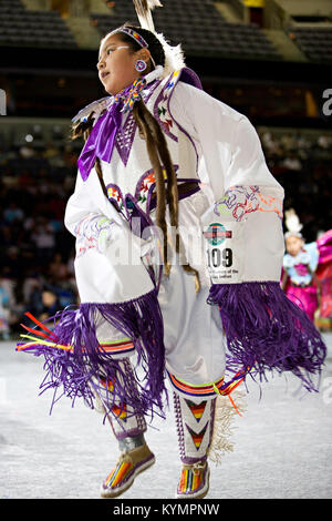 Cette image représente un jeune danseur amérindien participant à une compétition traditionnelle de danse pow-wow, mettant en vedette des regalia cérémoniels et des costumes de cuir, dans le cadre d'un événement culturel organisé au Musée national des Indiens d'Amérique. Banque D'Images