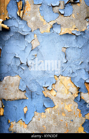 L'écaillement de peinture bleu rétro en ruine sur un vieux mur de plâtre, vieillissement et montrant des signes de vieillissement comme les briques vieillies commence à disparaître en couleur et Banque D'Images