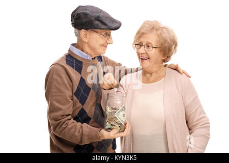 Couple de personnes âgées en mettant une pièce dans un pot d'argent isolé sur fond blanc Banque D'Images