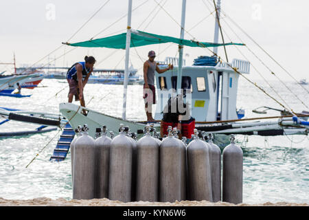 Une collection de plongeurs de la tâche demandée sur une plage de sable blanc tropicales avec la profondeur de champ en arrière de la mer calme et la pompe des bateaux. Banque D'Images