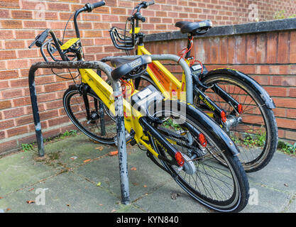 Deux YoBikes jaune en 2018 - qui sont dockless smart vélos pour voitures à Southampton, England, UK Banque D'Images