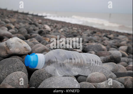 Bouteille d'eau en plastique échoués sur la plage de galets, sheringham, North Norfolk, Angleterre Banque D'Images