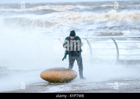 Blackpool Lancashire. 16 janvier 2018. Météo britannique. Des coups de vent à Blackpool. Un voyant orange "se préparer à l'avance, qui comprend des rafales de vent jusqu'à 50mph dans certains domaines, a été délivré pour l'ouest de l'Angleterre. Un photographe et son équipement prendre un bain comme des vagues se briser sur la promenade du front de mer. Credit:Media WorldImages/AlamyLiveNews Banque D'Images