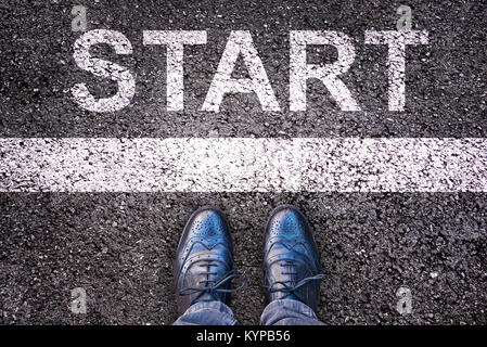 Démarrer Word écrit sur une route asphaltée, les jambes et les chaussures Banque D'Images