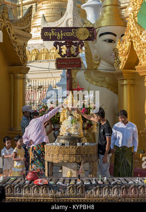 Verser de l'eau plus de fidèles, statue du Bouddha de la pagode Shwedagon, Yangon, Myanmar (Birmanie) Banque D'Images