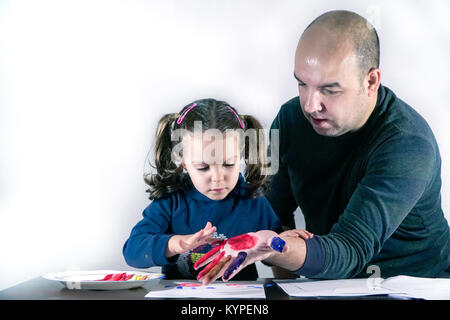 Jolie petite filles est sa peinture peintures colorées à la main les pères Banque D'Images