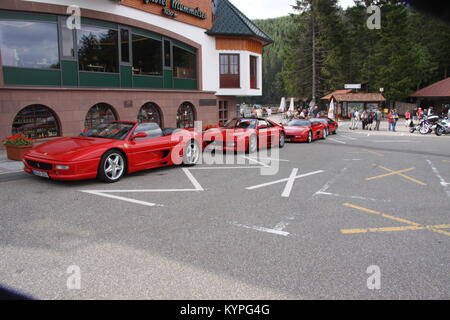 Quatre voitures Ferrari rouge sur une sortie club propriétaires alignés dans une rangée à l'extérieur d'une auto-route / zone de service cafe/restaurant dans la Forêt Noire Allemagne Banque D'Images