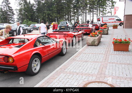 Quatre voitures Ferrari rouge sur une sortie club propriétaires alignés dans une rangée à l'extérieur d'une auto-route / zone de service cafe/restaurant dans la Forêt Noire Allemagne Banque D'Images