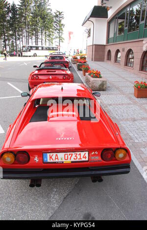 Quatre voitures Ferrari rouge sur une sortie club propriétaires alignés dans une rangée à l'extérieur d'une auto-route / zone de service cafe/restaurant dans la Forêt Noire Allemagne Banque D'Images