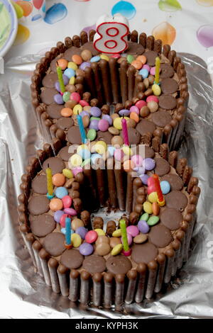 Gâteau d'anniversaire en forme de huit, fait à partir de boutons chocolat, biscuits au chocolat et smarties collés Banque D'Images