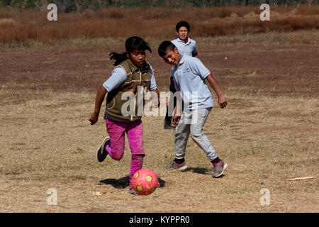 Les enfants jouent au soccer dans un champ au Mexique Banque D'Images