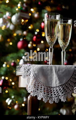 Verres sur une table, avec un arbre de Noël derrière Banque D'Images