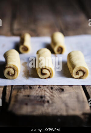 Les brioches à la cannelle sur table en bois avant la cuisson Banque D'Images