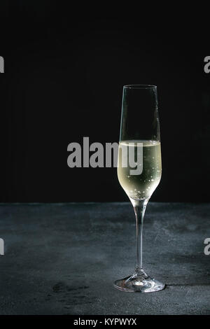 Un verre de champagne blanc foncé sur fond de texture. Copy space Banque D'Images