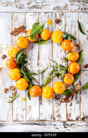 Mandarines Clémentines avec feuilles en couronne de Noël avec des bâtons de cannelle et anis sur fond blanc planche en bois. Vue de dessus, de l'espace. Nouvelle Année ca Banque D'Images