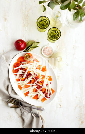 Le Jicama Salade de Grenade kaki avec Goyave Chevre Vinaigrette servi avec du vin blanc. Photographié sur un fond blanc. Banque D'Images