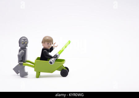 C3po lego pushing wheelbarrow tandis que Luke Skywalker assis. isolé sur fond blanc. Banque D'Images