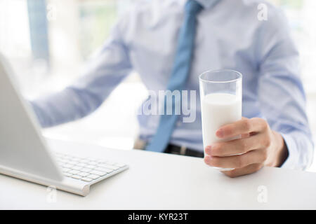 Young Woman drinking milk in office Banque D'Images