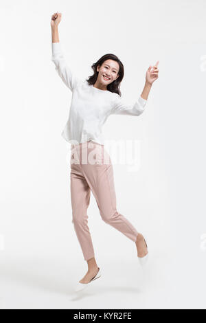 Cheerful young businesswoman jumping Banque D'Images