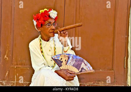 La HAVANE, CUBA, le 6 mai 2009. Une vieille femme assise avec un énorme cigare dans sa bouche et roses dans sa tête à La Havane, Cuba, le 7 mai 2009. Banque D'Images