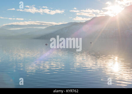 La lumière du soleil qui brille plus de montagnes et lac Skaha juste avant le coucher du soleil en hiver Banque D'Images