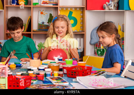 Petite fille aux étudiants la peinture au doigt en art school class. Banque D'Images