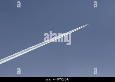 Jet laissant une traînée de vapeur derrière elle dans un ciel bleu. Banque D'Images