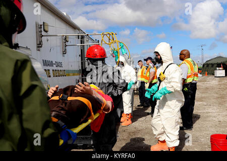 Soldats affectés à la 414e compagnie de produits chimiques à partir de Orangeburg, Caroline du Sud et les membres de l'équipe marchandises dangereuses de Miami-Dade pompiers travaillent ensemble pour décontaminer une victime simulée pendant un exercice de formation conjointe organisée par le Homestead-Miami Speedway et le service d'incendie de Miami-Dade à Miami, en Floride. 11 janvier, 2018. Cette JTE l'accent sur les capacités d'intervention et de construction d'une transition entre les premiers intervenants locaux et le suivi sur le soutien fourni par la Garde nationale et des soldats en service actif. (U. S. Army Banque D'Images