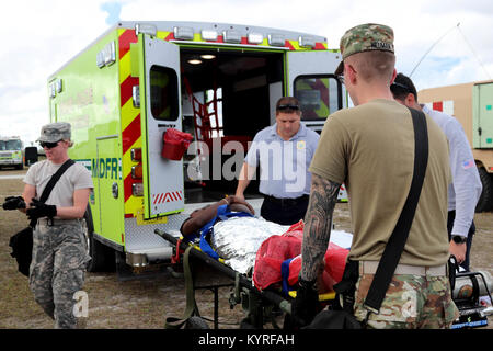 Soldats affectés à la 409ème Compagnie médicale de soutien de secteur de Madison (Wisconsin) et les membres de la Service d'incendie de Miami-Dade charger une victime simulée sur une ambulance pendant un exercice de formation conjointe organisée par le Homestead-Miami Speedway et le service d'incendie de Miami-Dade à Miami, en Floride. 11 janvier, 2018. Cette JTE l'accent sur les capacités d'intervention et de construction d'une transition entre les premiers intervenants locaux et le suivi sur le soutien fourni par la Garde nationale et des soldats en service actif. (U. S. Army Banque D'Images