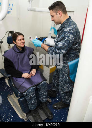 En Virginie (janv. 11, 2018) Hospitalman Dustin Garner, droite, prépare l'Aviateur de l'Aviation Mécanicien structurels Jaquelin Ramirez pour une radiographie à bord du porte-avions USS Dwight D. Eisenhower (CVN 69). Eisenhower est l'objet d'une disponibilité progressive prévue (PIA) au chantier naval de Norfolk au cours de la phase d'entretien de la flotte (Plan d'intervention optimisés OFRP). (U.S. Navy Banque D'Images