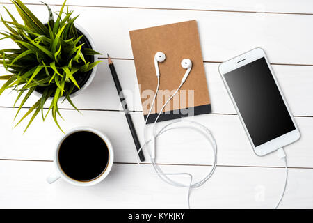 Smart phone blanc et accessoires sur une table en bois blanc. Vue d'en haut Banque D'Images