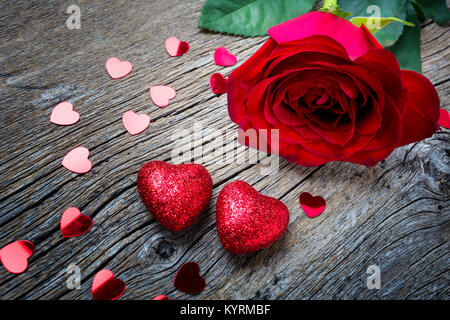 Valentines Day concept avec red rose, et le rose paillette le cœur sur le fond en bois rustique, de copier l'espace. Banque D'Images