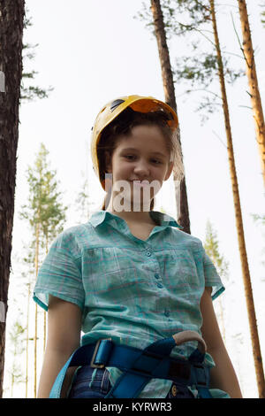 Portrait d'une jeune fille dans un casque et un équipement spécial pour l'escalade ou le treeclimbing. Extreme Sports et loisirs. Banque D'Images