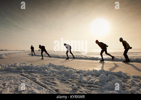 Les Pays-Bas, Hindeloopen, patin à glace sur le lac appelé IJsselmeer au coucher du soleil. L'hiver. Banque D'Images