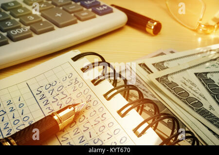 La budgétisation de l'argent. Réservez avec les calculs, la calculatrice et dollars. Banque D'Images