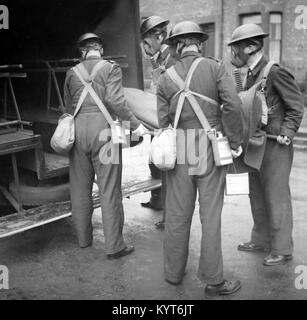 Le chargement d'une personne blessée dans une ambulance, exercice de formation ARP pendant WW2 Banque D'Images