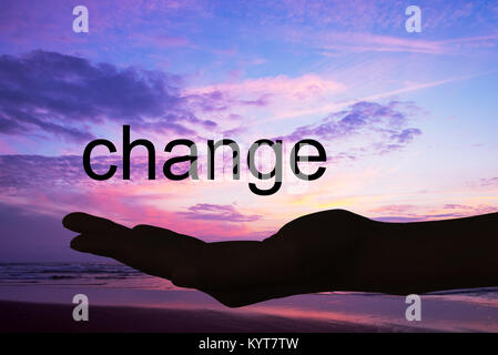 Main offrant le mot changement, fond coucher de soleil Banque D'Images