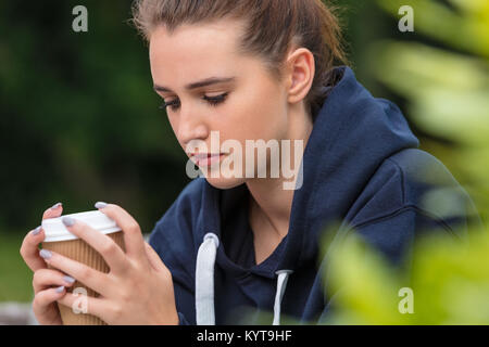 Belle fille déprimé triste adolescent femme jeune femme à boire le café à emporter à l'extérieur Banque D'Images