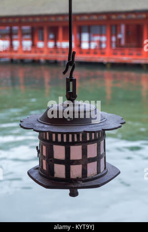 Une lanterne est suspendu au plafond sur un fond d'eau et un passage au sanctuaire d'Itsukushima à Miyajima, Hiroshima.. Banque D'Images