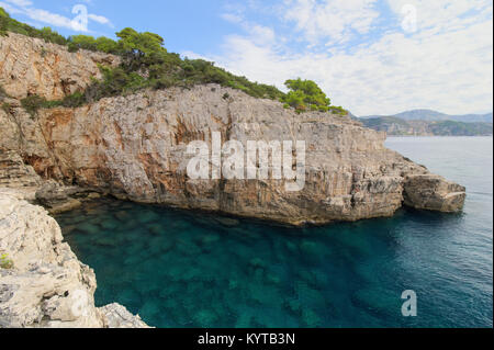 Vue panoramique sur une mer vide cave, l'eau peu profonde et falaise abrupt et accidenté sur l'île de Lokrum en Croatie. Banque D'Images