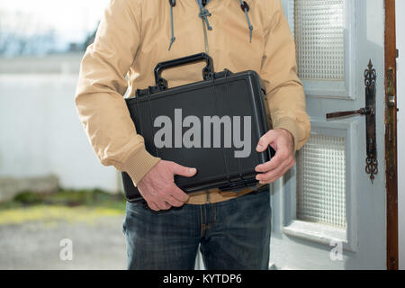 Un homme avec une valise noire going home Banque D'Images