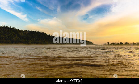 / Le fleuve Ganga Gange coulant en pleine vigueur à Triveni Ghat, Rishikesh, Uttarakhand, Inde. Belle vue autour de coucher du soleil/crépuscule/heure d'or. Teintes Orange Banque D'Images