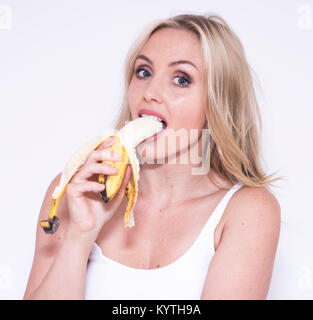 Très jolie jeune femme manger une banane Banque D'Images