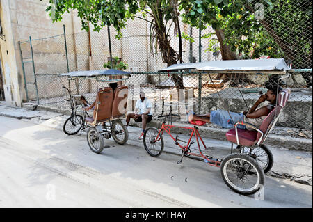 La HAVANE, CUBA, le 6 mai 2009. Deux pousse-pousse et leurs pilotes en attente dans la rue à La Havane, Cuba, le 6 mai 2009. L'autre conducteur est assis dans sa Banque D'Images