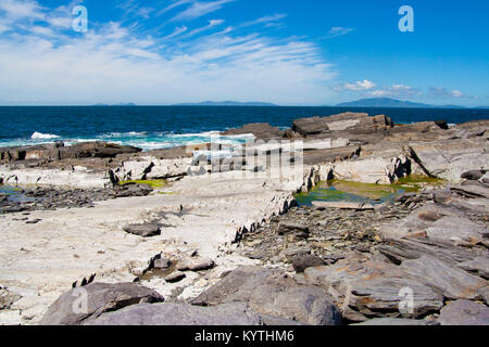 L'ardoise de la ligne de côte au point Cromwell,Valentia Island, Ring de Kerry, Irlande rockpools avec cirrus Banque D'Images